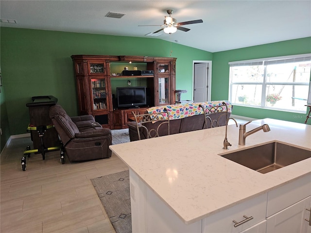 13156 Merlot Sunstone Cv, Parrish, FL 34219 - kitchen featuring a sink, lofted ceiling, a ceiling fan, light stone countertops, and white cabinets