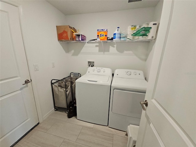 13156 Merlot Sunstone Cv, Parrish, FL 34219 - laundry area featuring washing machine and dryer and light tile patterned floors