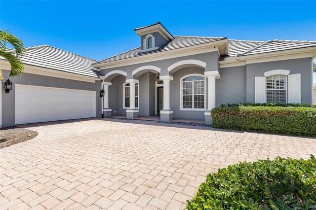 52 Grande Fairway, Englewood, FL 34223 - view of front of property featuring stucco siding, a garage, decorative driveway, and a tile roof