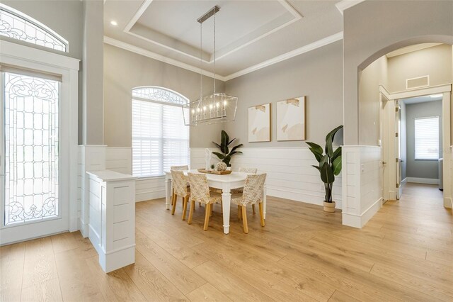 52 Grande Fairway, Englewood, FL 34223 - dining room featuring light wood finished floors, wainscoting, a tray ceiling, a chandelier, and arched walkways