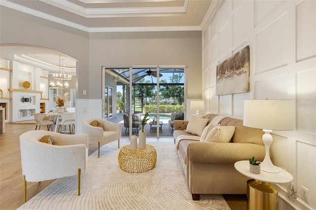 52 Grande Fairway, Englewood, FL 34223 - living room with a decorative wall, crown molding, a sunroom, arched walkways, and a tray ceiling