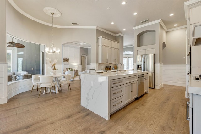 52 Grande Fairway, Englewood, FL 34223 - kitchen with stainless steel appliances, a sink, ornamental molding, arched walkways, and wainscoting