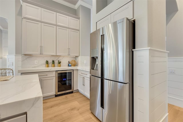 52 Grande Fairway, Englewood, FL 34223 - kitchen with stainless steel fridge with ice dispenser, beverage cooler, crown molding, light stone countertops, and light wood finished floors