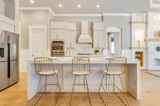 52 Grande Fairway, Englewood, FL 34223 - kitchen with appliances with stainless steel finishes, custom exhaust hood, ornamental molding, light wood-type flooring, and recessed lighting