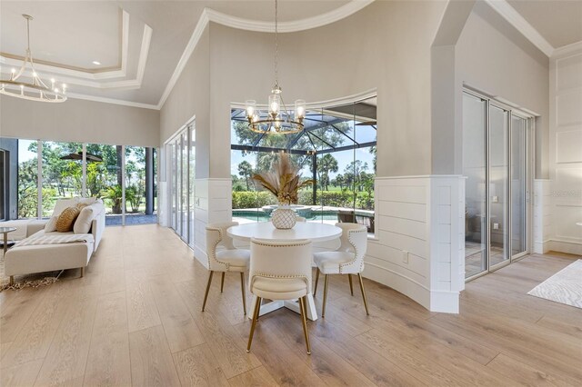 52 Grande Fairway, Englewood, FL 34223 - dining space with a chandelier, light wood-style flooring, a towering ceiling, ornamental molding, and wainscoting