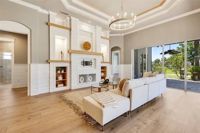 52 Grande Fairway, Englewood, FL 34223 - living room with arched walkways, crown molding, wood-type flooring, a chandelier, and a raised ceiling