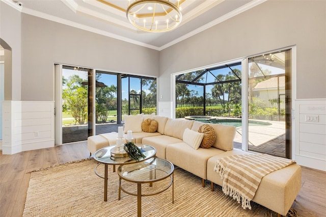 52 Grande Fairway, Englewood, FL 34223 - living area featuring a sunroom, crown molding, a wainscoted wall, wood finished floors, and arched walkways