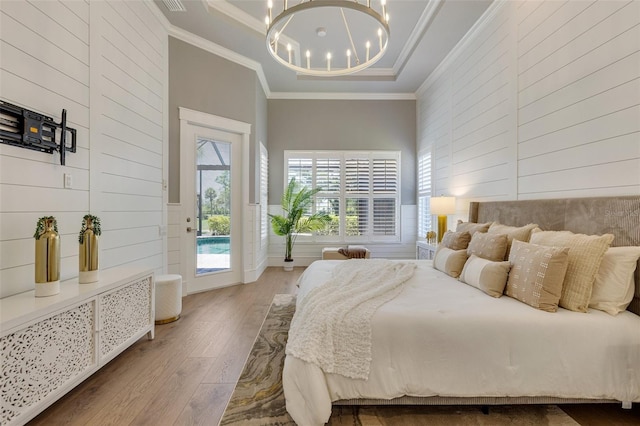 52 Grande Fairway, Englewood, FL 34223 - bedroom featuring hardwood / wood-style floors, access to outside, wooden walls, ornamental molding, and a chandelier