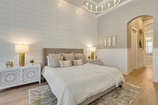 52 Grande Fairway, Englewood, FL 34223 - bedroom featuring ornamental molding, arched walkways, wood finished floors, a chandelier, and a wainscoted wall
