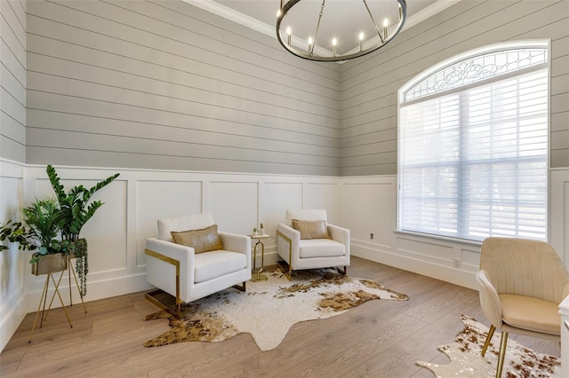 52 Grande Fairway, Englewood, FL 34223 - living area featuring a chandelier, wood finished floors, crown molding, wainscoting, and a decorative wall