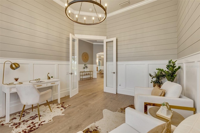 52 Grande Fairway, Englewood, FL 34223 - living area featuring ornamental molding, a chandelier, arched walkways, light wood finished floors, and a decorative wall