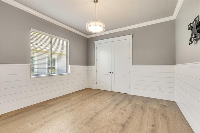 52 Grande Fairway, Englewood, FL 34223 - spare room with wainscoting, crown molding, light wood-type flooring, and wooden walls