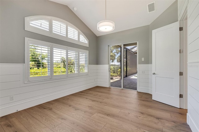 52 Grande Fairway, Englewood, FL 34223 - unfurnished room featuring lofted ceiling, wainscoting, and light wood-style floors