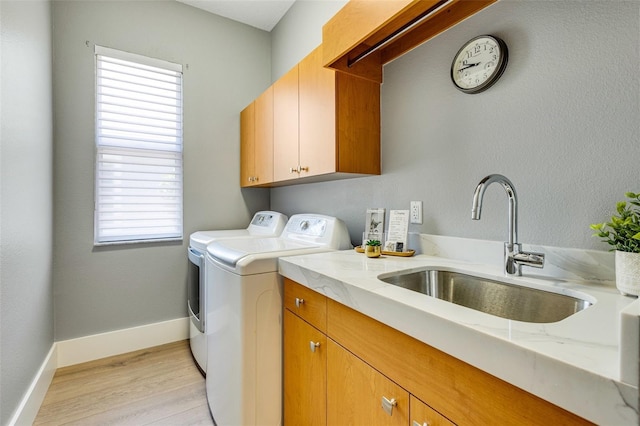 52 Grande Fairway, Englewood, FL 34223 - clothes washing area featuring washer and clothes dryer, cabinet space, light wood-style floors, and baseboards