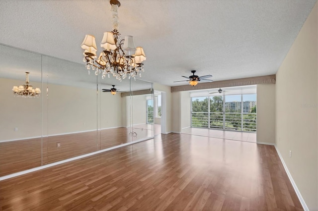 3750 Pinebrook Cir Unit 405, Bradenton, FL 34209 - unfurnished living room with a chandelier, a textured ceiling, ceiling fan, wood finished floors, and baseboards
