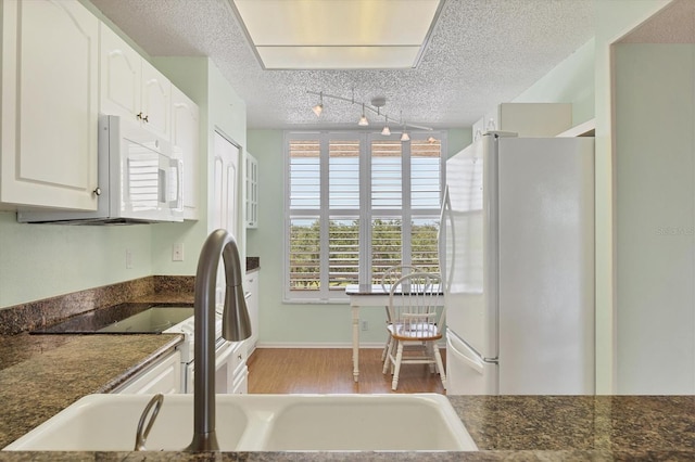 3750 Pinebrook Cir Unit 405, Bradenton, FL 34209 - kitchen with white appliances, a sink, dark countertops, white cabinetry, and a textured ceiling