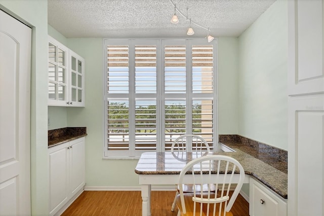 3750 Pinebrook Cir Unit 405, Bradenton, FL 34209 - dining area featuring a textured ceiling, light wood-type flooring, and baseboards