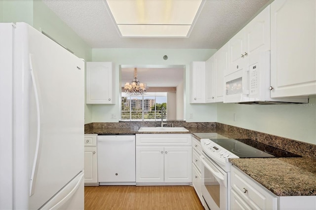 3750 Pinebrook Cir Unit 405, Bradenton, FL 34209 - kitchen with white appliances, a sink, a chandelier, white cabinetry, and light wood finished floors