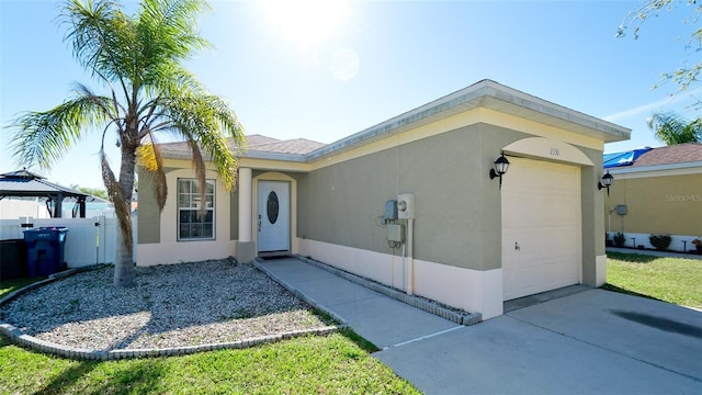 2330 28th Ave E, Palmetto, FL 34221 - view of front of house featuring a garage, driveway, stucco siding, and a gazebo