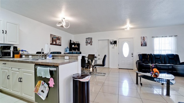 2330 28th Ave E, Palmetto, FL 34221 - kitchen with open floor plan, a sink, light tile patterned floors, dark countertops, and a textured ceiling