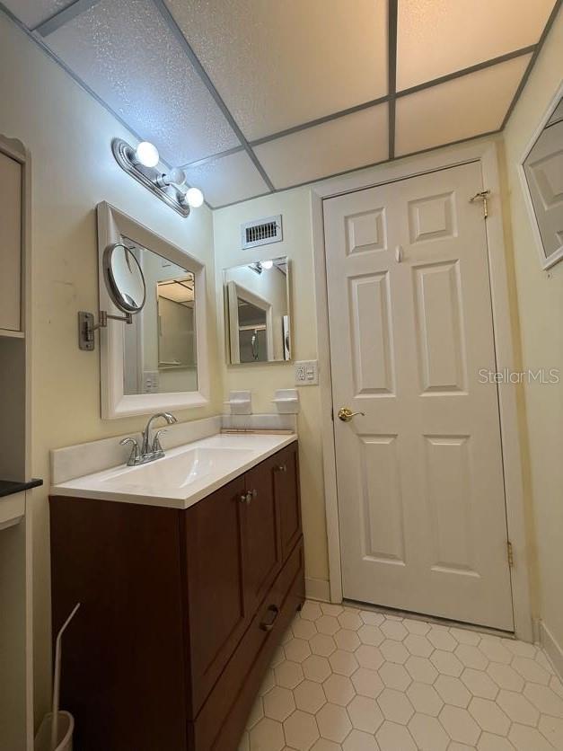 1304 56th St W Unit 1304, Bradenton, FL 34209 - bathroom featuring vanity, tile patterned flooring, a paneled ceiling, and baseboards