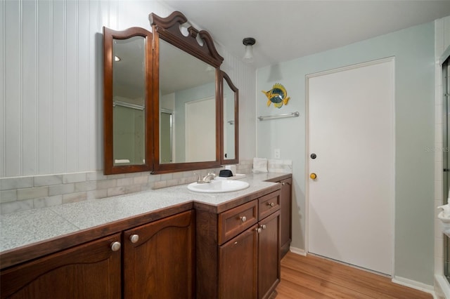 7202 18th Ave NW, Bradenton, FL 34209 - full bathroom featuring vanity, wood finished floors, a shower with shower door, and tasteful backsplash