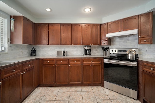 7202 18th Ave NW, Bradenton, FL 34209 - kitchen featuring electric stove, under cabinet range hood, backsplash, and a sink