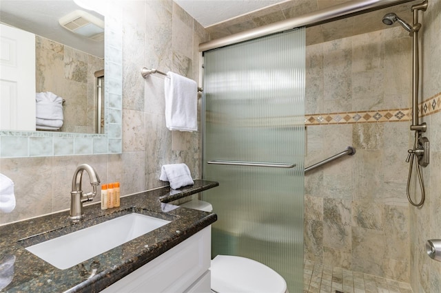 4621 Gulf Of Mexico Dr Unit 2F, Longboat Key, FL 34228 - bathroom with a stall shower, vanity, toilet, and tile walls