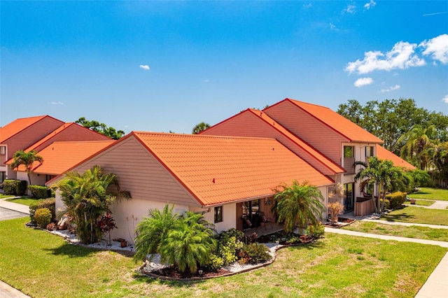 6462 Draw Ln Unit 72, Sarasota, FL 34238 - view of home's exterior featuring a tiled roof, stucco siding, a yard, and a garage
