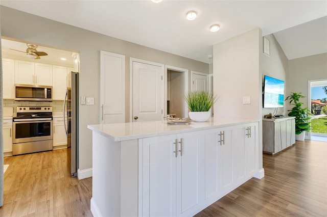 6462 Draw Ln Unit 72, Sarasota, FL 34238 - kitchen with appliances with stainless steel finishes, light wood-style floors, backsplash, light countertops, and white cabinets