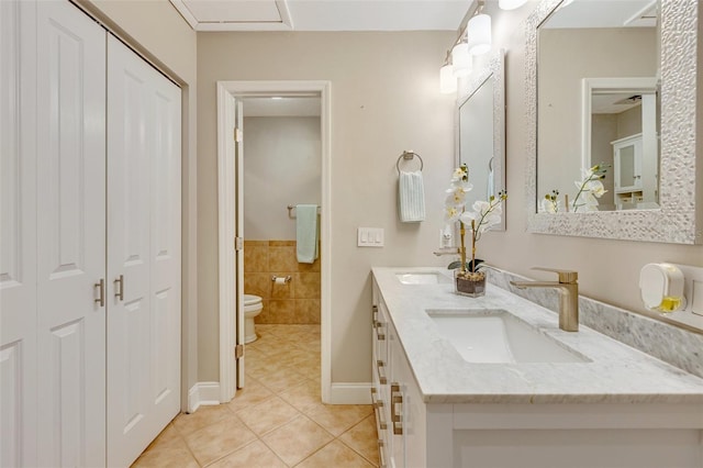 6462 Draw Ln Unit 72, Sarasota, FL 34238 - bathroom featuring tile patterned floors, toilet, a closet, double vanity, and tile walls