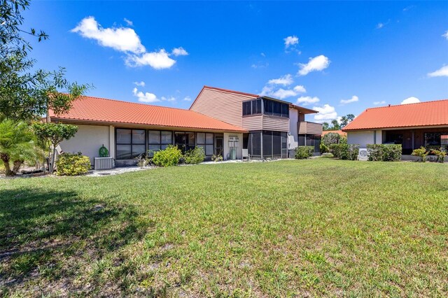 6462 Draw Ln Unit 72, Sarasota, FL 34238 - rear view of house featuring a sunroom, cooling unit, and a lawn