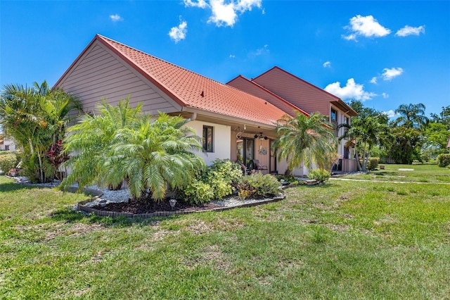 6462 Draw Ln Unit 72, Sarasota, FL 34238 - view of property exterior with a lawn, stucco siding, and a tile roof