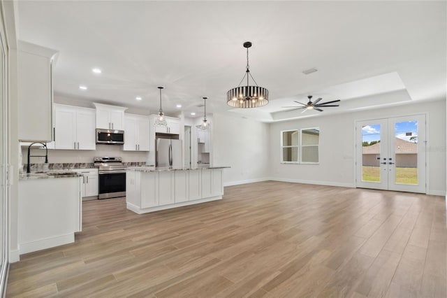 2704 Gaspar Ave, North Port, FL 34288 - kitchen with appliances with stainless steel finishes, recessed lighting, open floor plan, light wood-type flooring, and white cabinetry