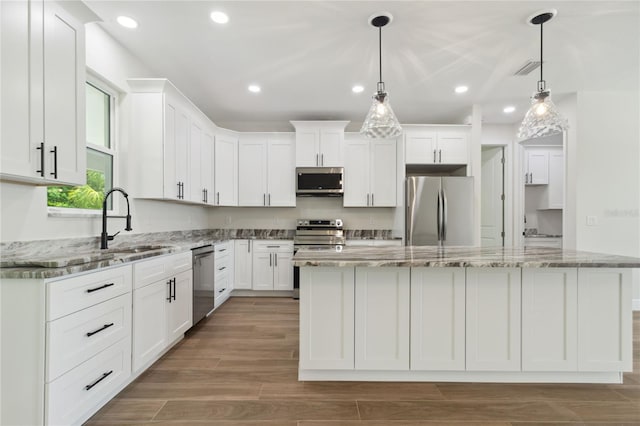 2704 Gaspar Ave, North Port, FL 34288 - kitchen featuring appliances with stainless steel finishes, white cabinetry, a kitchen island, a sink, and recessed lighting