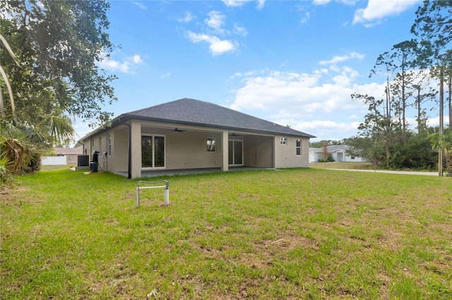2704 Gaspar Ave, North Port, FL 34288 - back of property featuring a ceiling fan, a lawn, stucco siding, and central air condition unit
