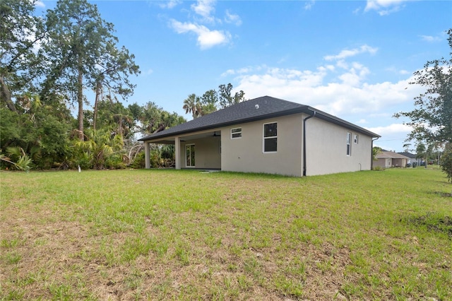 2704 Gaspar Ave, North Port, FL 34288 - rear view of property with a lawn and stucco siding