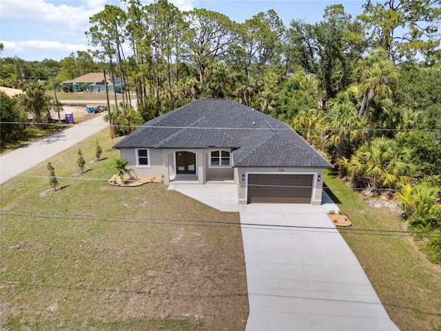 2704 Gaspar Ave, North Port, FL 34288 - view of front of home featuring a shingled roof, concrete driveway, an attached garage, a front lawn, and stucco siding