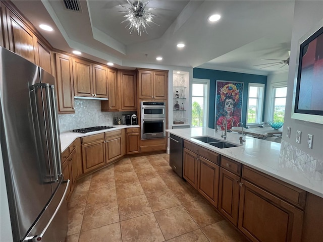 130 Riviera Dunes Way Unit 304, Palmetto, FL 34221 - kitchen with stainless steel appliances, a ceiling fan, brown cabinetry, backsplash, and ornamental molding