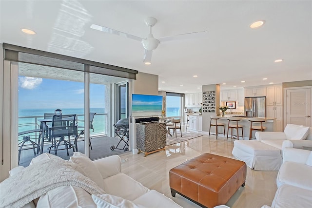 living room featuring recessed lighting, light tile patterned floors, a ceiling fan, and a wall of windows