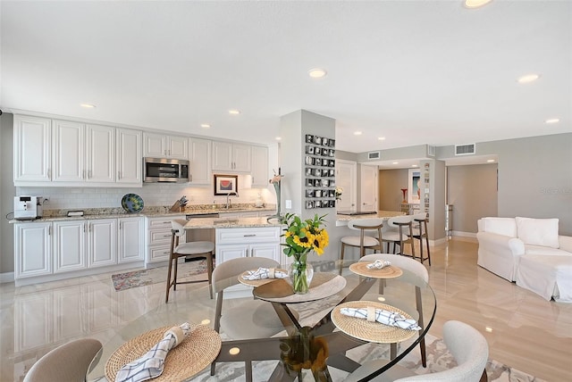 dining space with recessed lighting and baseboards