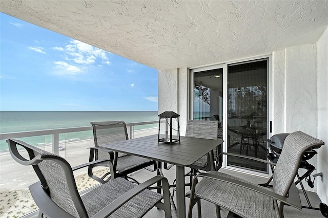 balcony featuring a water view and outdoor dining space