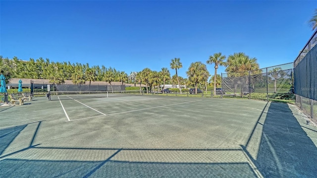 view of tennis court featuring fence and community basketball court