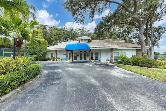 5804 Garden Lakes Fern, Bradenton, FL 34203 - view of front of house with french doors, driveway, fence, stucco siding, and a tile roof