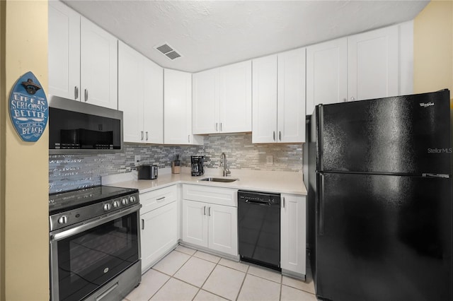 2037AND2039 Jo An Dr, Sarasota, FL 34231 - kitchen with black appliances, light tile patterned flooring, light countertops, tasteful backsplash, and white cabinets