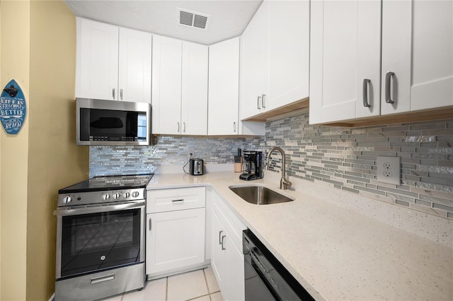 2037AND2039 Jo An Dr, Sarasota, FL 34231 - kitchen with stainless steel appliances, decorative backsplash, and white cabinets