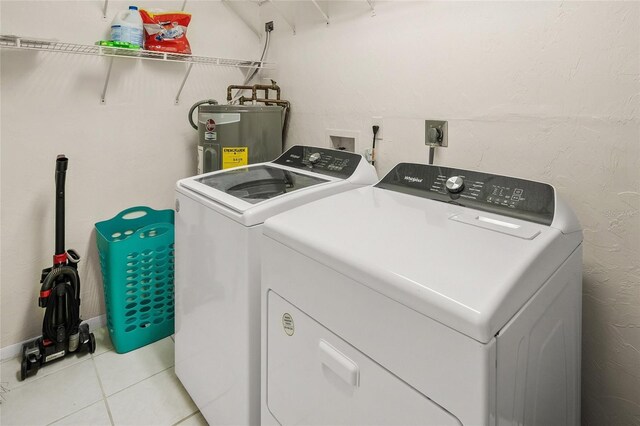 2037AND2039 Jo An Dr, Sarasota, FL 34231 - laundry area featuring washer and clothes dryer, water heater, and light tile patterned flooring