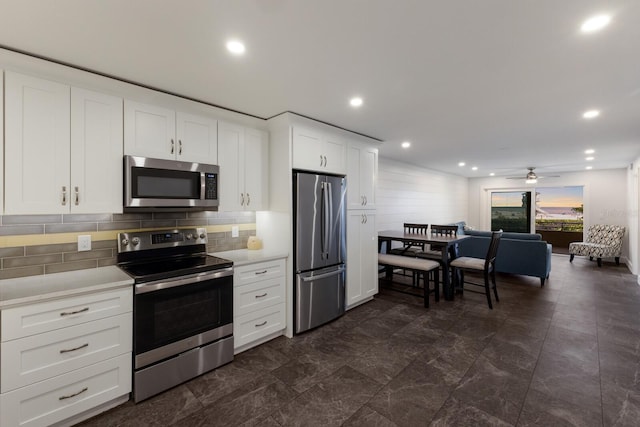 kitchen featuring appliances with stainless steel finishes, ceiling fan, light countertops, backsplash, and white cabinetry