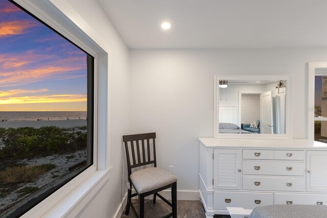 living area featuring baseboards, a water view, and recessed lighting