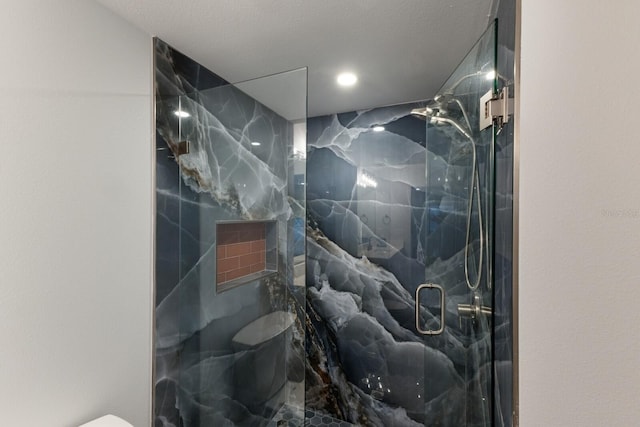 bathroom featuring a marble finish shower